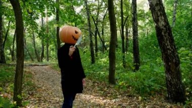 Halloween. Sonbahar ormanında bıçakla yürüyen balkabağı olan çılgın ve neşeli bir adam..