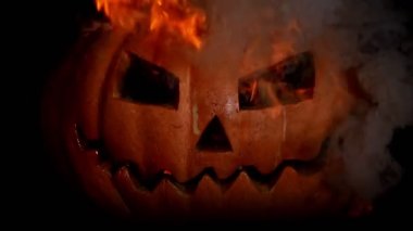 Cehennem alev yanan ateşte korkunç oyulmuş halloween balkabağı. Gözlerden ateş ve ağızdan dişler le dolu duman