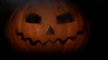 Karanlık karşısında ateş ile ürkütücü kabak jack-o-fener yüz. 4k. Cadılar Bayramı konsepti. Çılgın ve korkunç yüz ifadesi.
