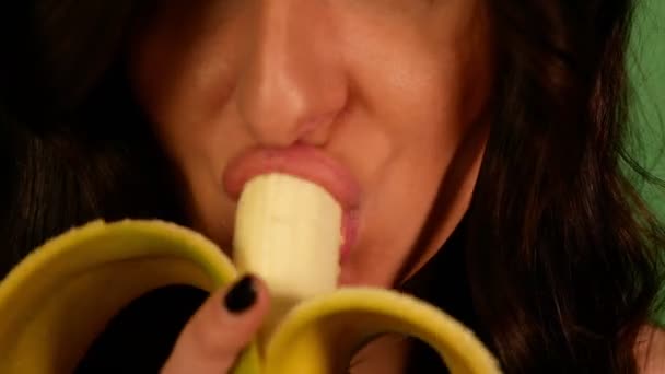 Крупный План Брюнетка Женщина Жадно Едят Банан Зеленый Фон — стоковое видео