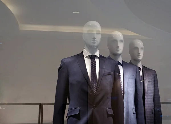 A group of mannequins in strict business suits.