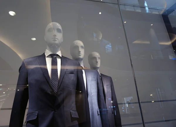 A group of mannequins in strict business suits.