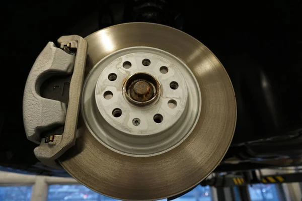 Brake disc and brake caliper on a modern car. Repair and maintenance of a modern car.