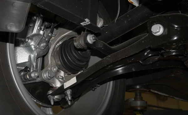 A close-up shows the drive shaft of a wheel of a modern car mounted on a car.
