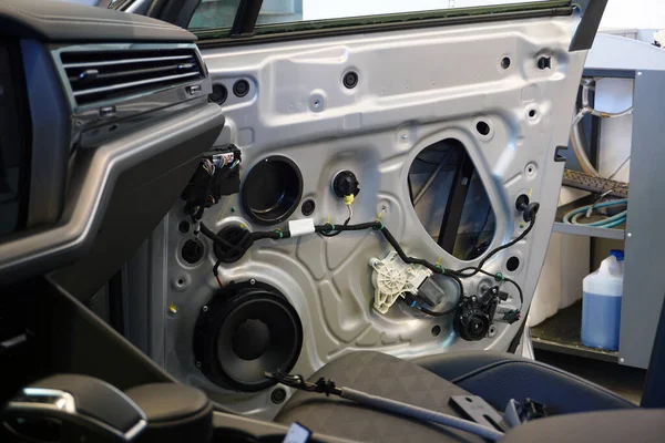 İç astarı modern bir arabanın kapısından sökülmüş. Kapı girişinde kabloları, müzik hoparlörünü, güç penceresi motorunu görebilirsiniz. Araç servisi ve elektroteşhis kavramı.