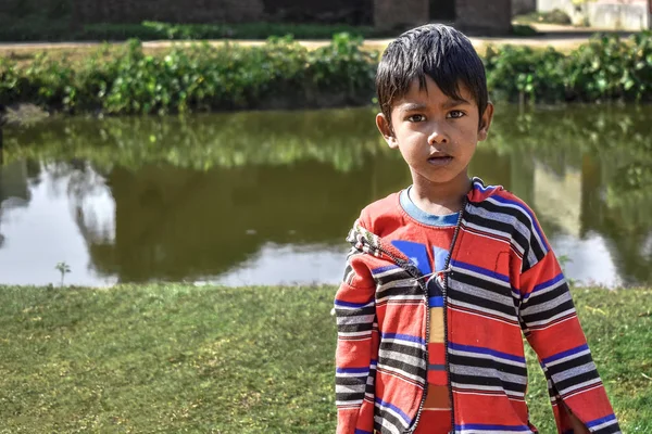 Een onschuldige arme jongen van India die naar de camera kijkt — Stockfoto