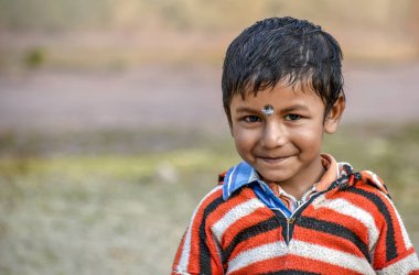 Sevimli gülümseyen çocuk gülümseyerek ve kameraya bakarak