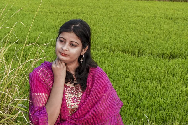 Portret van een jong Indisch meisje zittend in een rijstveld, wearin — Stockfoto