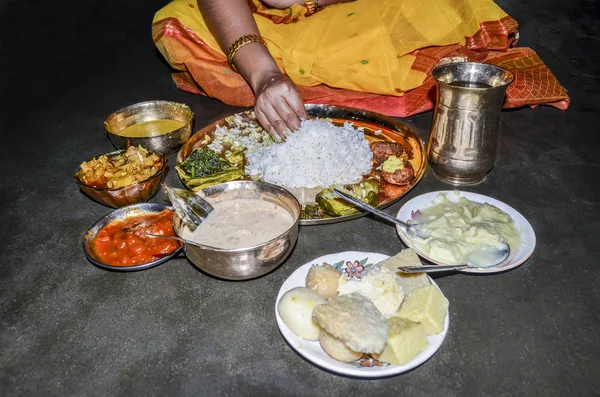 Indian woman eating vegetarian thali by her hand