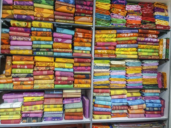 Tradicional ropa india colorida apilada en una sala de exposición textil — Foto de Stock