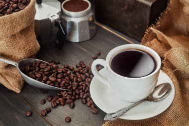 Kahve fincanı, çanta, kepçe ve kahve makinesi pot ile kahve çekirdekleri.