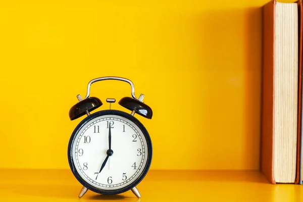 Reloj Despertador Libro Sobre Fondo Amarillo Con Espacio Para Copiar — Foto de Stock