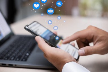 Sosyal medyada sosyal iletişim için elinde akıllı telefon tutan erkek, bilgilendirme mesajı, yorum mesajı ve yıldızı, dijital pazarlama ve sosyal medya kavramı ile elini uzattı.