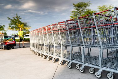 Bir bakkal işçisi yakınındaki bakkal arabaları Row