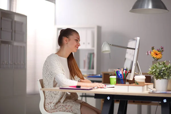 Mujer joven trabajando en la oficina, sentada en el escritorio. Mujer joven . — Foto de Stock