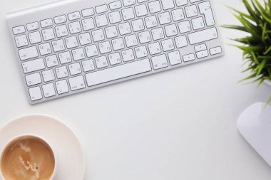 Bilgisayar ve kahve fincanı ahşap masada..