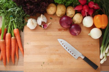 Mutfaktaki masanın üstünde sebzeler var. .