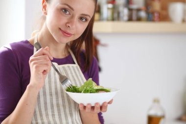 Genç kadın taze salata modern mutfakta yemek. Mutfak at genç kadın
