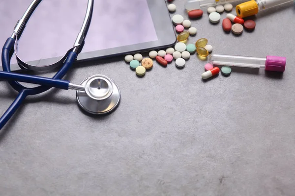 Zdravotnické zařízení: blue stetoskop a tablet na šedém pozadí. — Stock fotografie