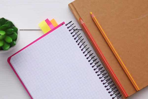 Üstten görünüm görüntüsünü içeren ahşap masa boş sayfalardan açık defter. Not defterini açın.