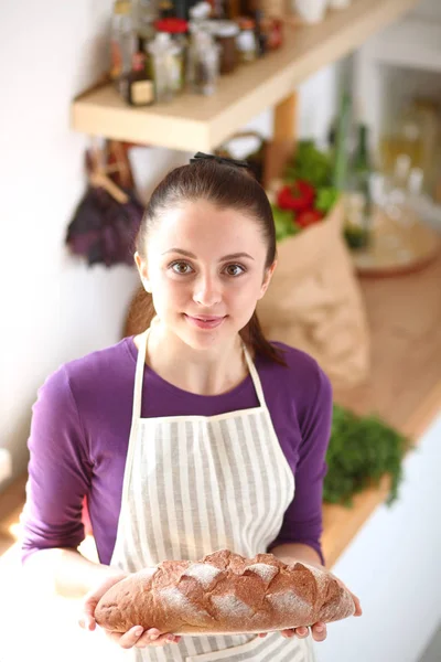 Giovane donna che tiene gustoso pane fresco nella sua cucina. Giovane donna. pane fresco — Foto Stock