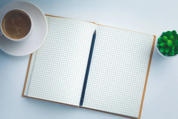 Vista superior de la imagen de cuaderno abierto con páginas en blanco junto a la taza de café en la mesa de madera . — Foto de Stock