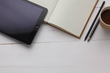 Açık defter ile ahşap masa üzerinde kahve yanındaki boş sayfa görüntüsünü üstten görünüm.