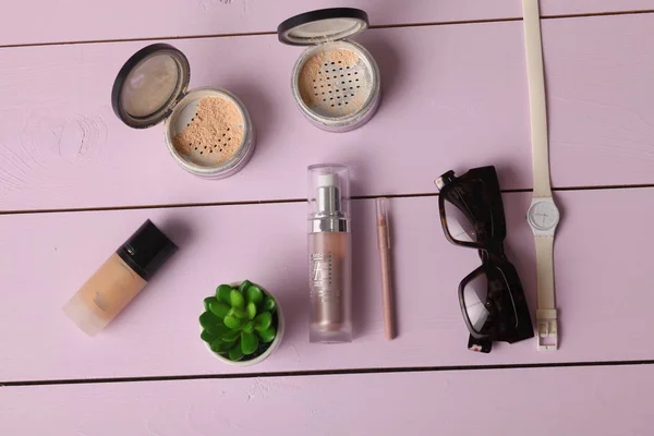 Okulary przeciwsłoneczne, kosmetyki makijaż i essentials na podłoże drewniane. — Zdjęcie stockowe