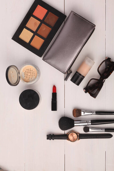 Makeup brush and cosmetics, on a white background.