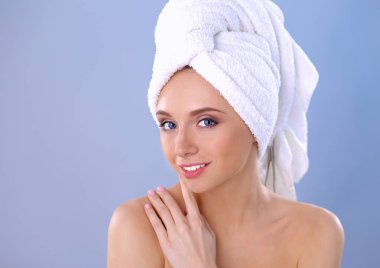 Güzel kadın başını gri bir arka plan üzerine bir havlu ile