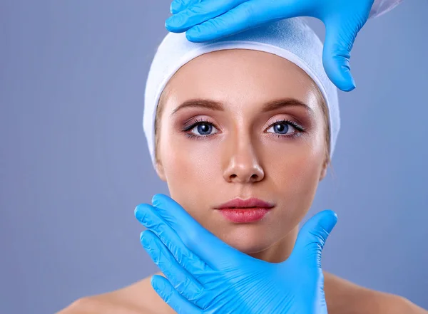 A surgeons hands touching a female face — Stock Photo, Image