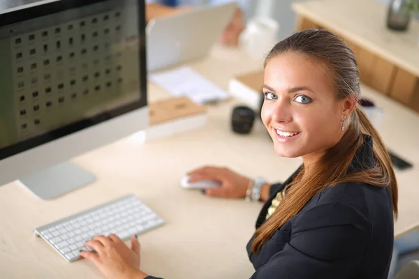 Ung kvinna som arbetar på kontor, sitter vid skrivbord, använder laptop — Stockfoto