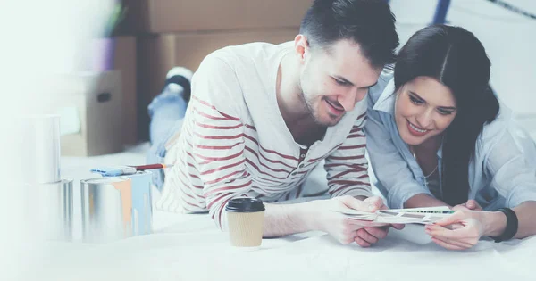 Paar verf kleur kiezen uit staal voor nieuw huis liggend op houten vloer — Stockfoto