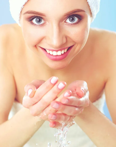 Young female washing her face with clear water