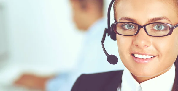 Gelukkig vrouwtje draagt een headset en zit op het bureau — Stockfoto