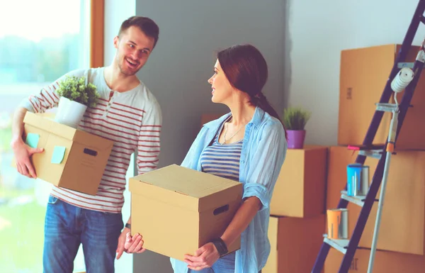 Mutlu genç çift açma veya kutu ambalaj ve yeni evine taşıdıktan