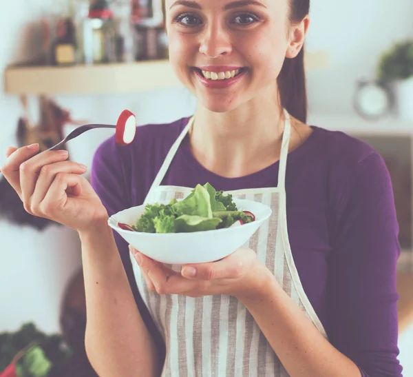 Jonge vrouw die verse salade eet in de moderne keuken — Stockfoto