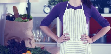 Onun mutfak masa alışveriş torbaları ile yakın duran genç kadın