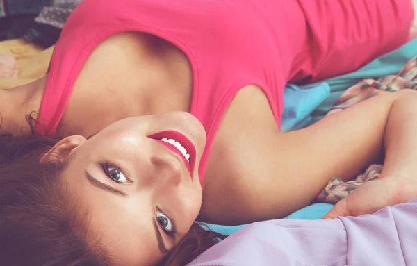 Mujer joven bonita sentada en la cama con bolsas de compras —  Fotos de Stock