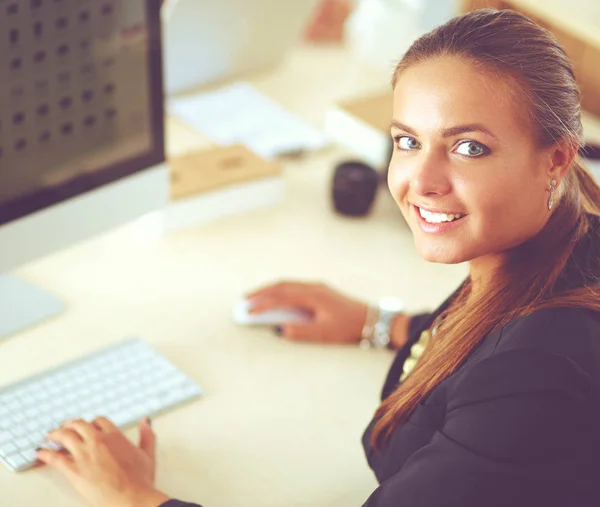 Jonge vrouw werkzaam in kantoor, zit op Bureau, met behulp van laptop — Stockfoto