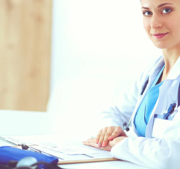 Portrait of young female doctor sitting at desk in hospital — Stock Photo, Image
