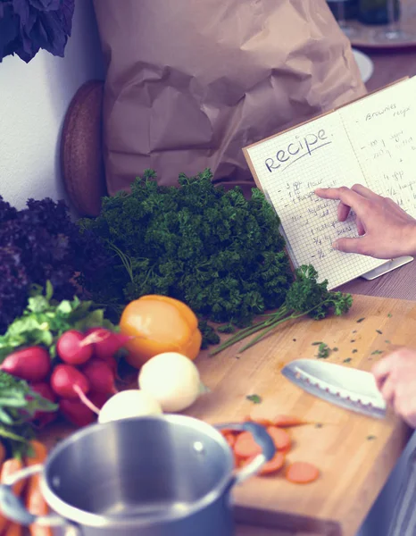 Jonge vrouw die groenten snijdt in de keuken — Stockfoto