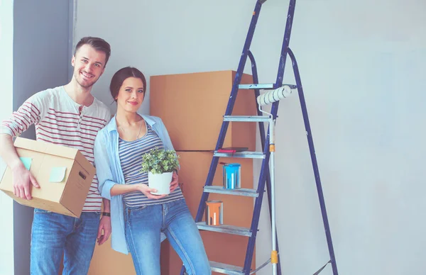 Glada unga par uppackning eller packa lådor och flyttar till ett nytt hem. — Stockfoto