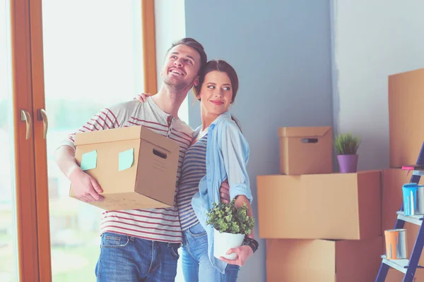 Glada unga par uppackning eller packa lådor och flyttar till ett nytt hem. — Stockfoto