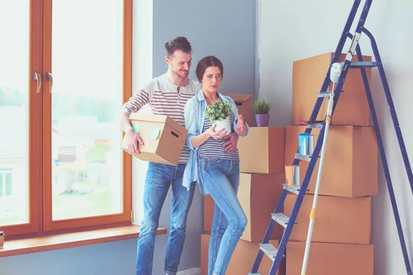 Glada unga par uppackning eller packa lådor och flyttar till ett nytt hem. — Stockfoto