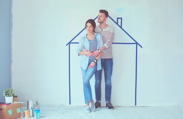 Staande voorzijde geschilderde woning op muur (echt) paar. Jong koppel — Stockfoto