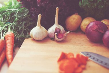 Mutfaktaki masanın üstünde sebzeler var. .