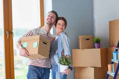 Mutlu genç çift açma veya kutu ambalaj ve yeni evine taşıdıktan.