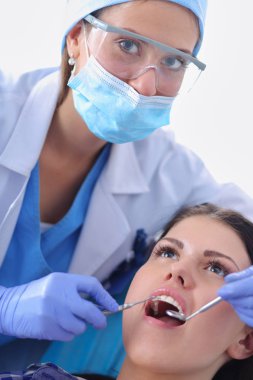 Hasta dişlerini çalışan kadın dişçi. Kadın diş hekimi
