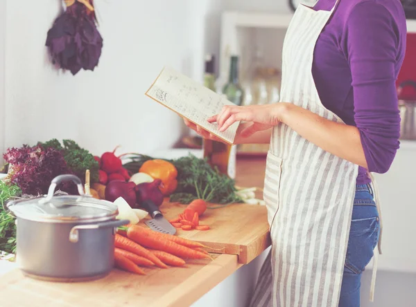 Junge Frau liest Kochbuch in der Küche, auf der Suche nach Rezept. junge Frau — Stockfoto